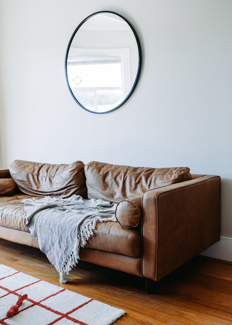 living room couch with round mirror