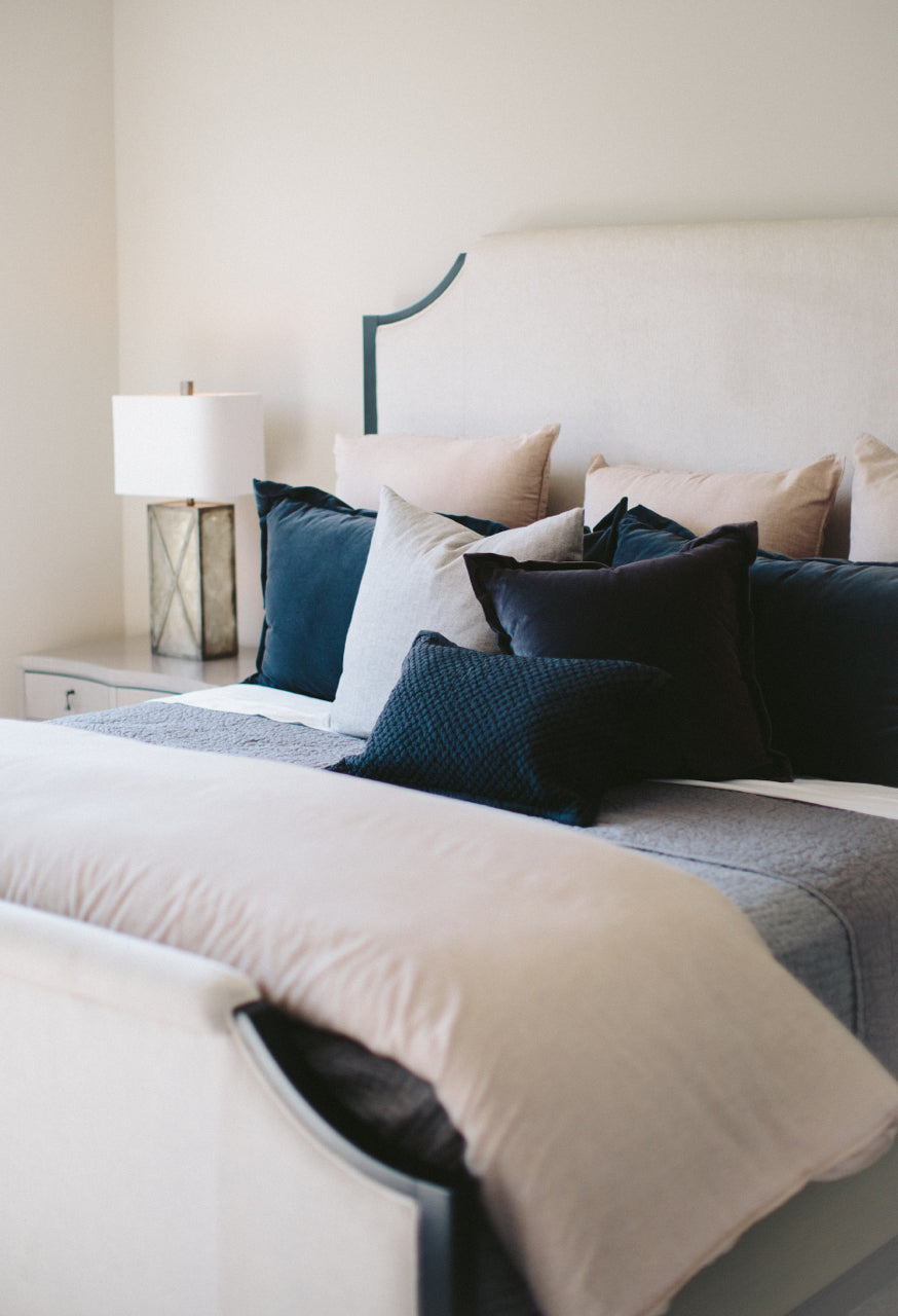 bed with peach, navy and neutral bedding