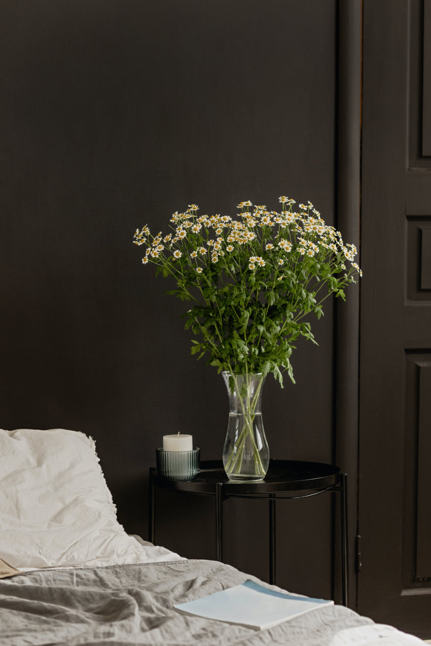 fresh flowers in bedroom with black wall