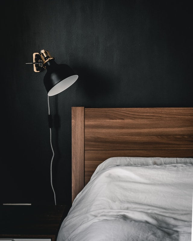 brown headboard with dark black accent wall