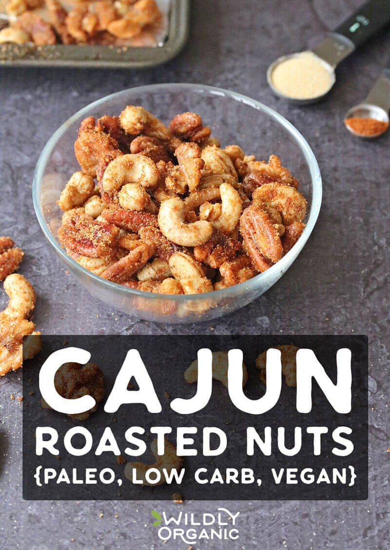 Photo of cajun spiced nuts in a glass bowl and scattered around.