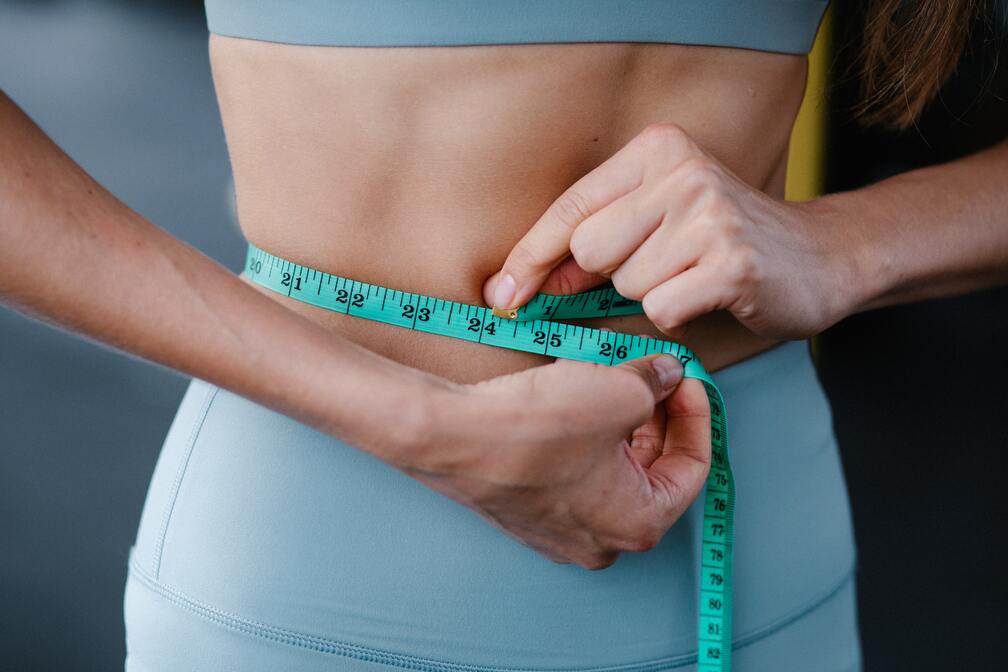 A woman measuring her waist