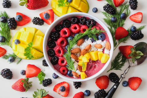 Big bowl of healthy berries, fruits, nuts, and coconut