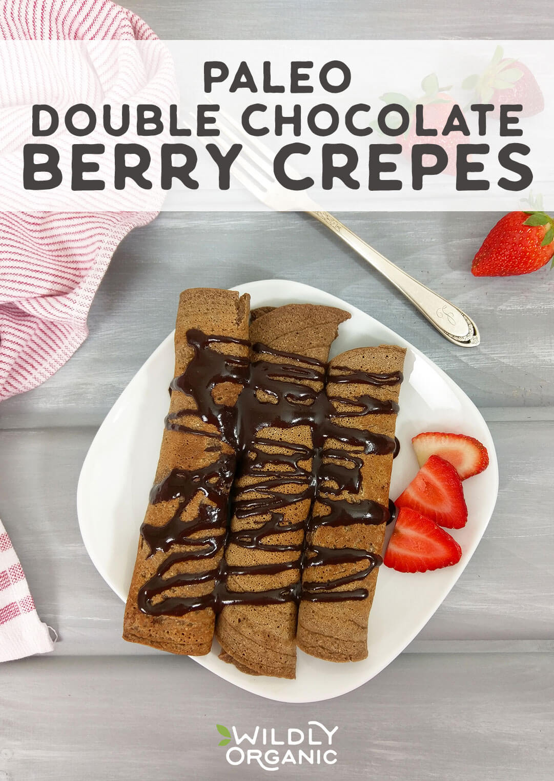 Photo of a plate of paleo double chocolate crepes from above with strawberries on the side.