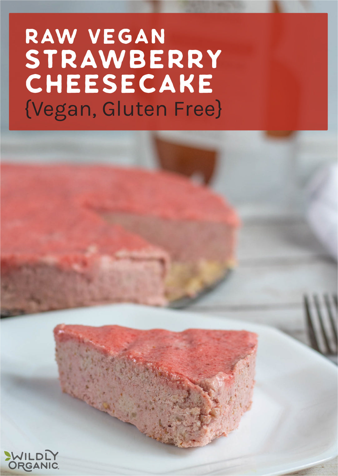 a piece of raw strawberry cheesecake on a white plate with a fork next to it and Wildly Organic packaging in the background