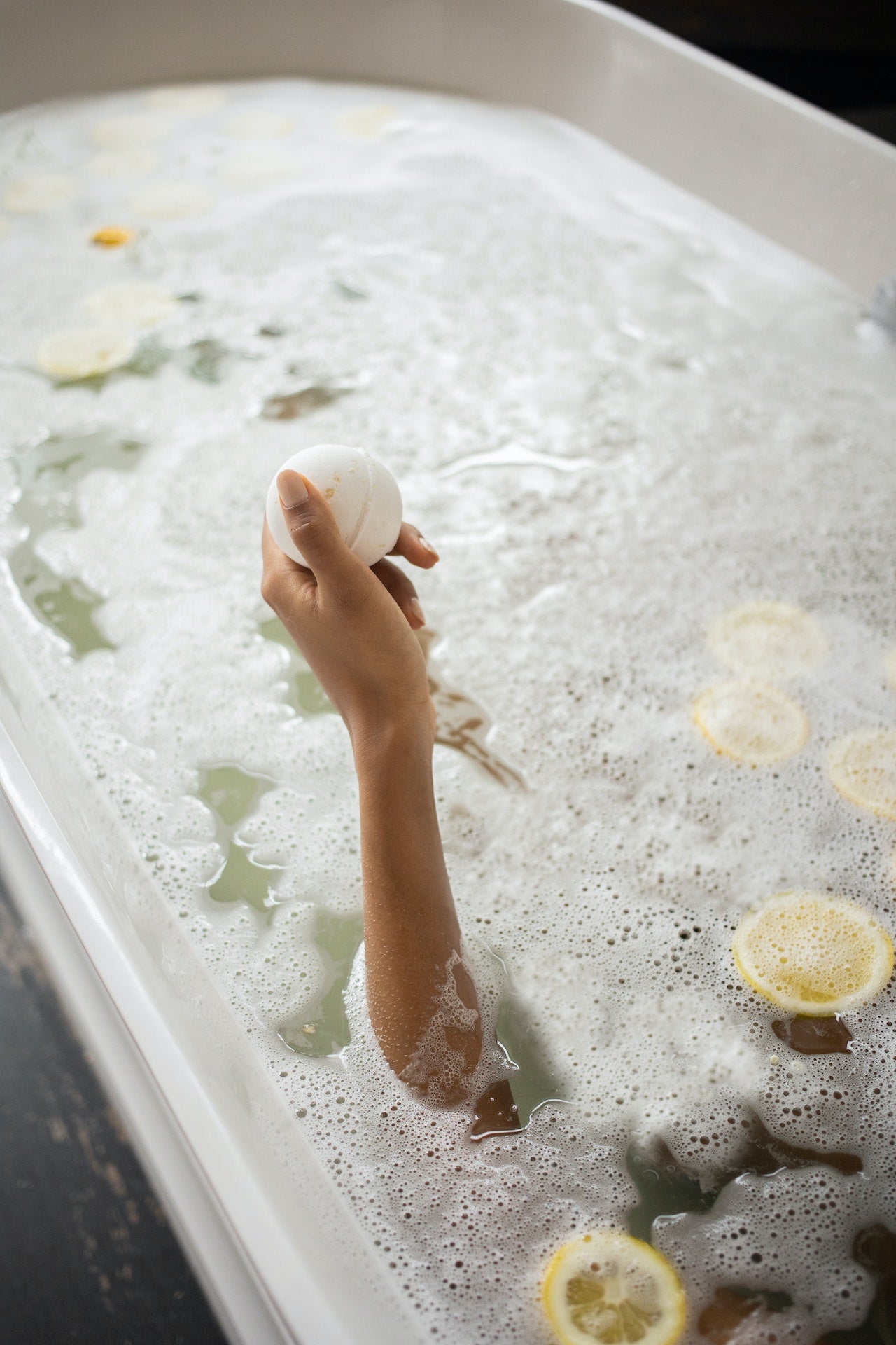  A woman taking a bath and holding a bath salt