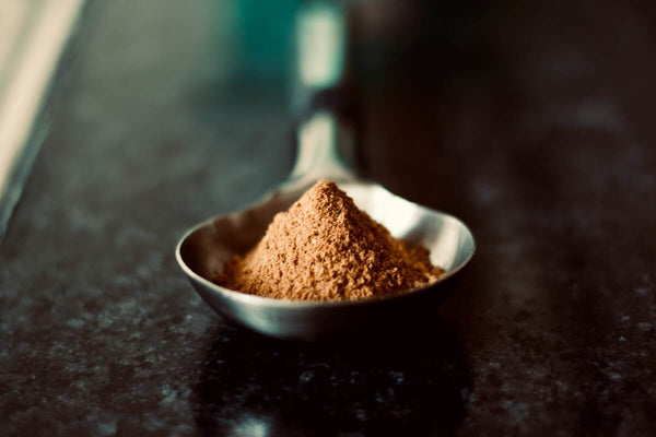 A heap of brown powder inside a silver spoon