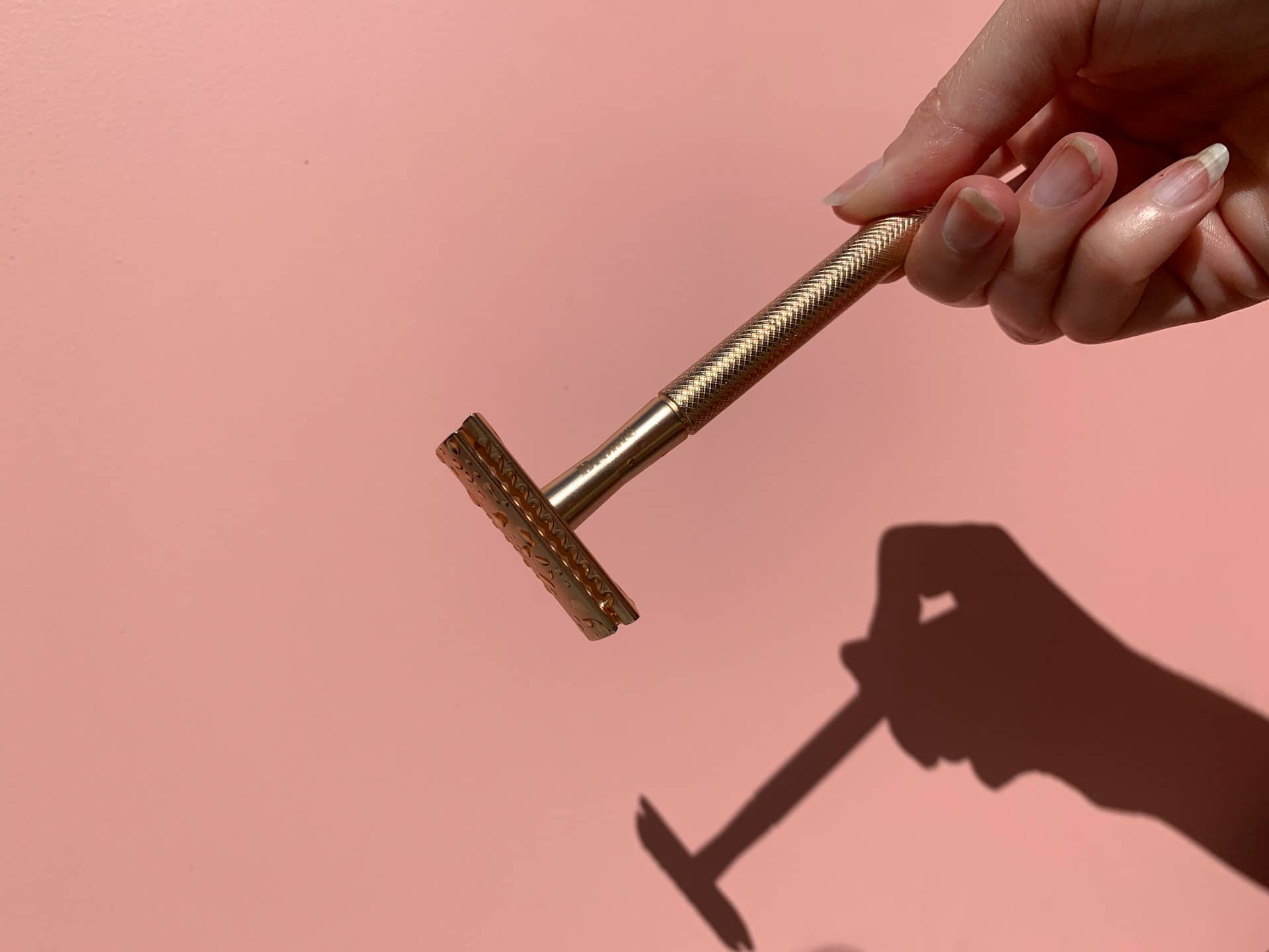 Woman holding metal razer casting a shadow