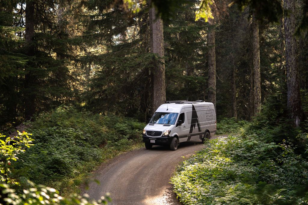 atlas pet company 4x4 sprinter van in mt baker wilderness with sunlight coming through trees on dirt road