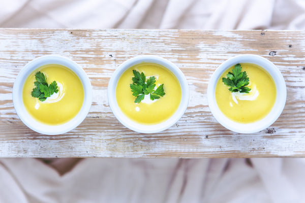 bowl of chicken soup on a piece of wood