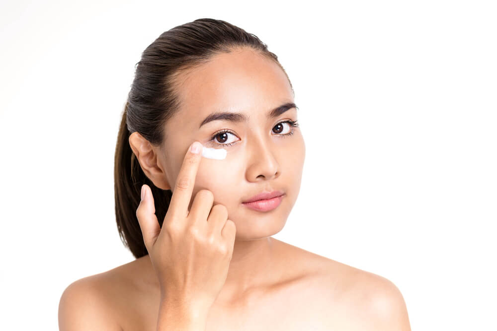 woman applying eye cream with finger