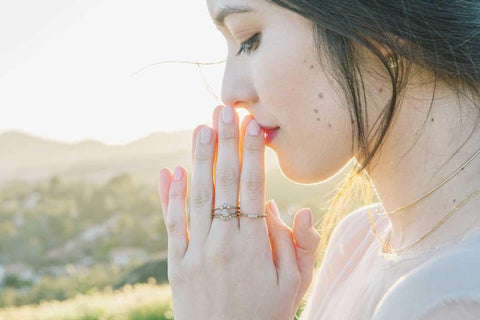 Jennie Kwon Rings UK - Model wearing multiple Jennie Kwon rings in a sunny field