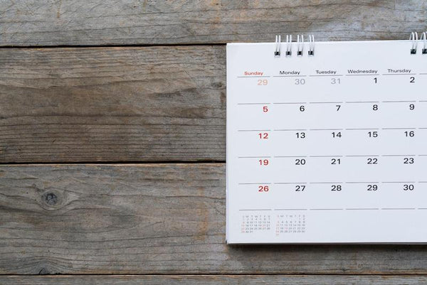 A month calendar sitting on a wooden background.