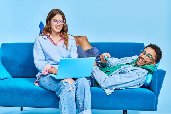 Funky eyeglasses: couple happily hanging out on their couch