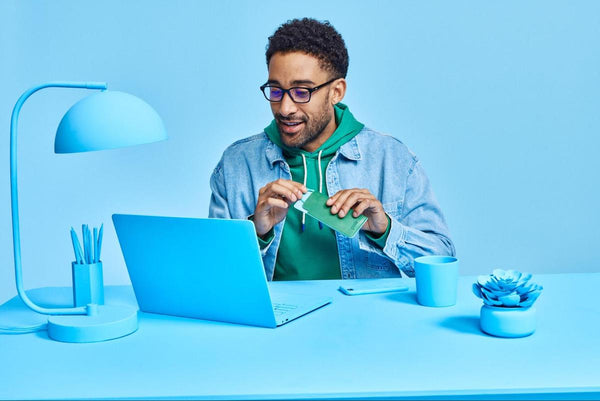 Man looking at his blue laptop