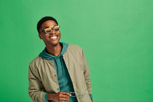 Man smiling while wearing a pair of trendy sunglasses