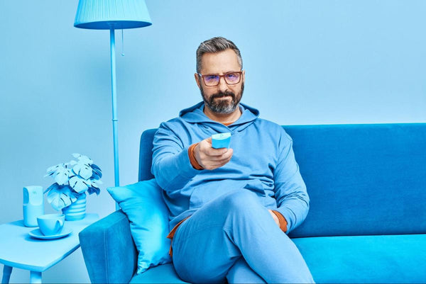 Blue light glasses benefits: man using a remote control