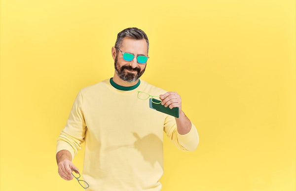 Man wearing The Casper while holding 2 pairs of eyeglasses