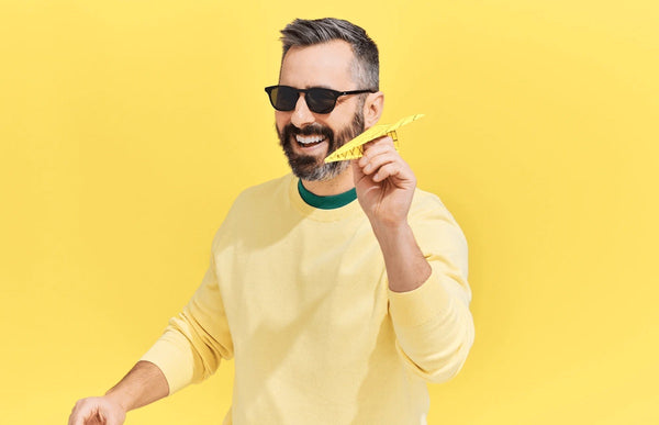 Man wearing The Otis while holding a paper airplane