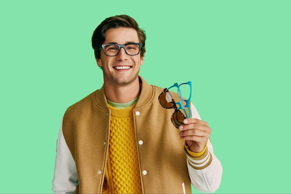 Big frame glasses: man wearing a pair of eyeglasses while holding 3 pairs of eyeglasses