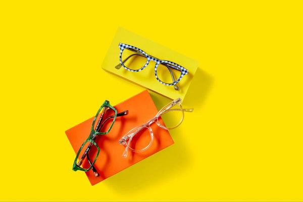 Three pairs of glasses with colorful patterns sit on a yellow background.