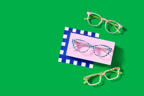 Three pairs of women's eyeglasses with colorful patterns from Pair Eyewear on a green background.