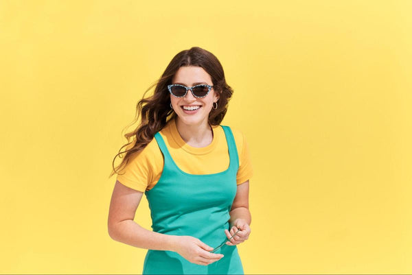 Triangle face shape glasses: woman happily wearing sunglasses