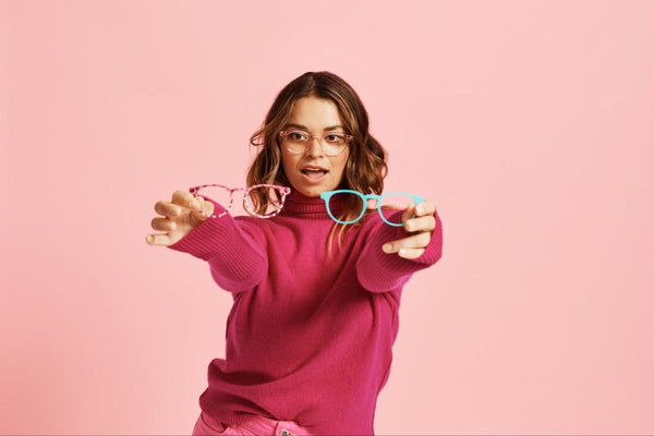 Woman holding 2 pairs of eyeglasses