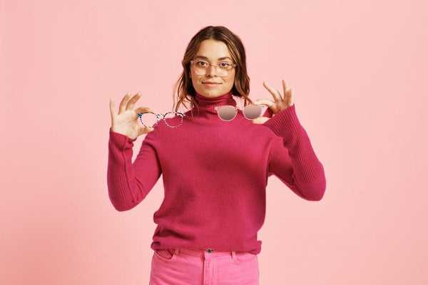 Progressive transition lenses: woman holding 2 pairs of eyeglasses