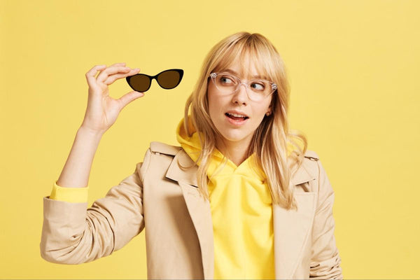 Clear style glasses: woman holding a pair of Ella glasses