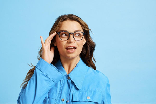 Affordable optical: woman holding her eyeglasses while looking up