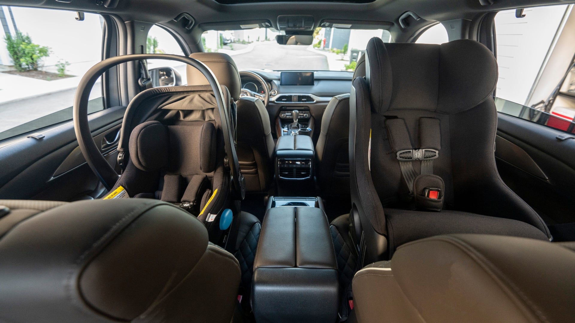 Two black Clek car seats installed in a car rearfacing