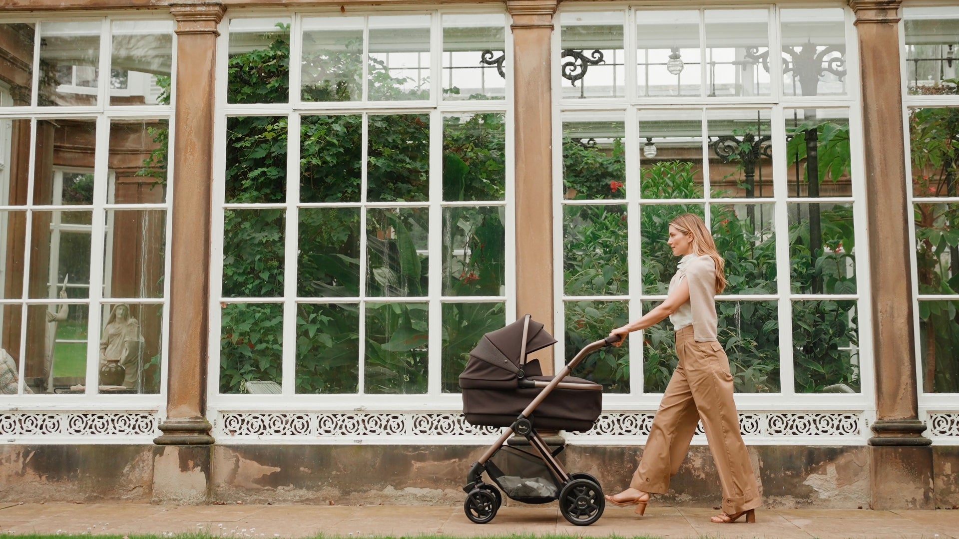 Woman walking Silver Cross Reef 2 with bassinet