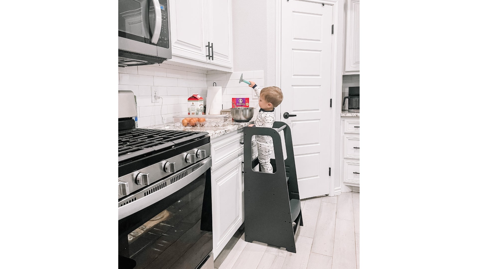 Toddler boy in toddler tower baking