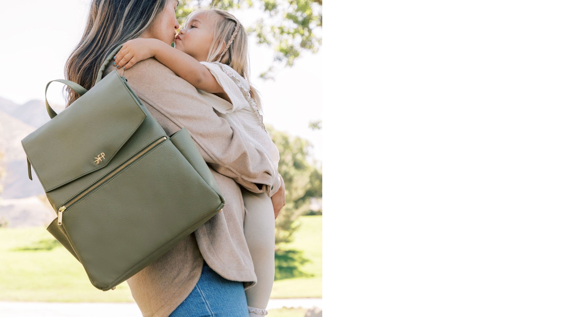 Woman holding child with Freshly Picked Classic Diaper Bag on her shoulder