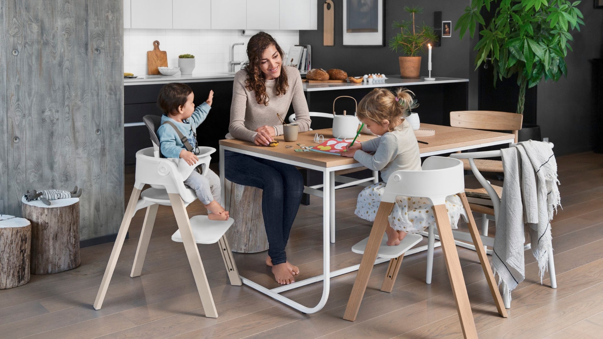 Two children in Stokke Steps chairs around a table