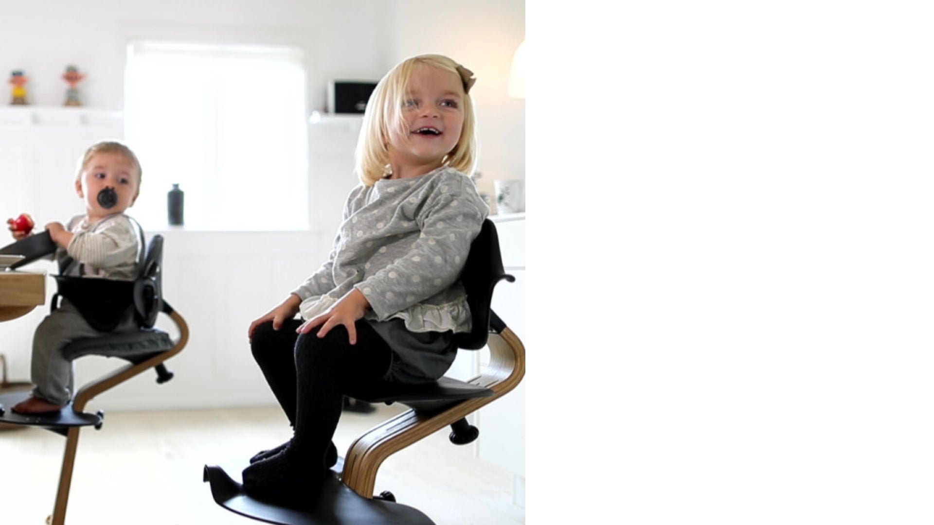 Two children on Nomi high chairs