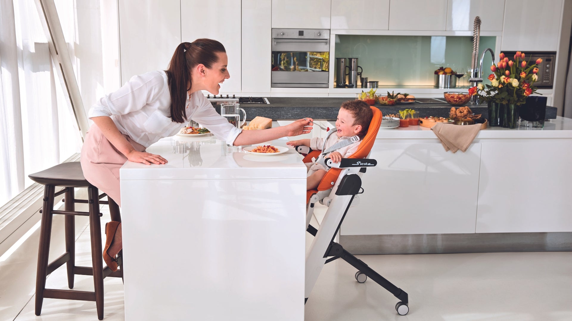 Mom feeding baby in the Siesta high chair