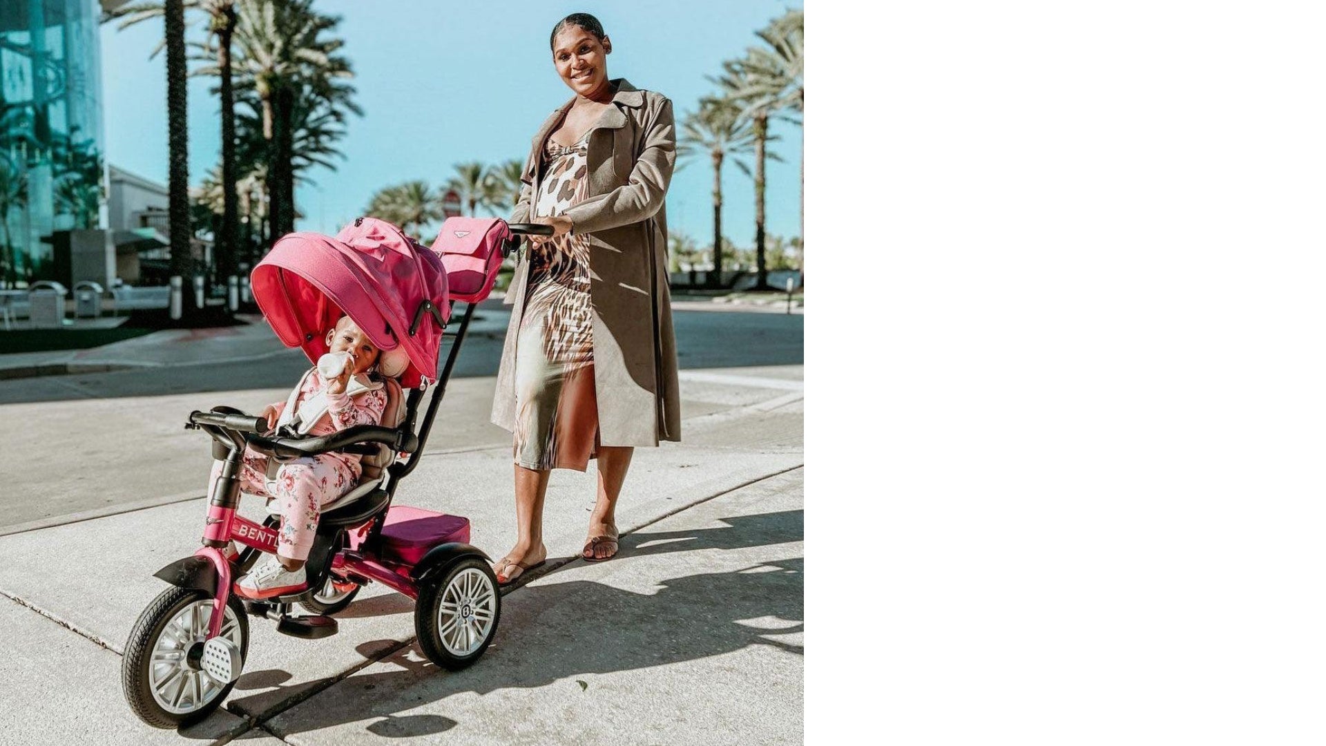 Mom pushing toddler in pink Bentley Trike