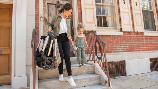 Mother Carrying a Lightweight Nuna Stroller Down Stairs