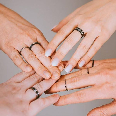 Four hands touching with stackable rings pairings