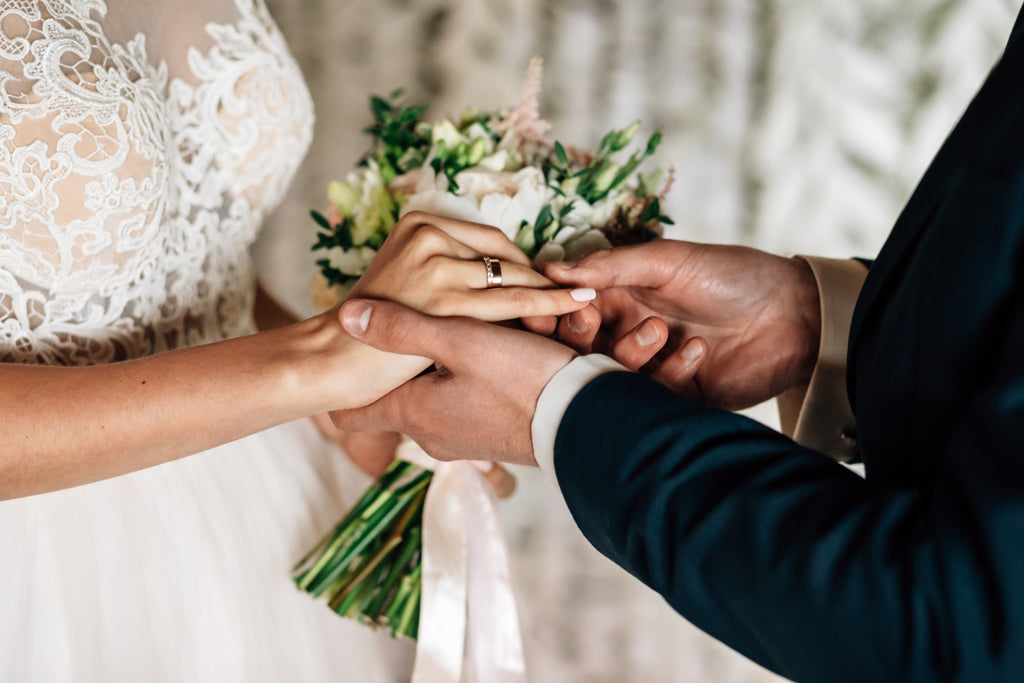 Groom exchanging wedding bands with bride