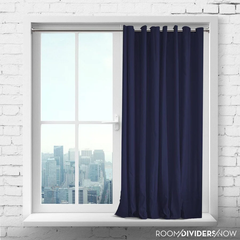 a navy blue color curtain hanged from a galvanized curtain rod near the window
