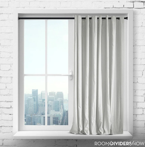 a picture of a white window with a black tension rod and a white curtain hanging