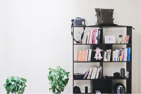 a trendy shelving unit in black holding various books and other household items]