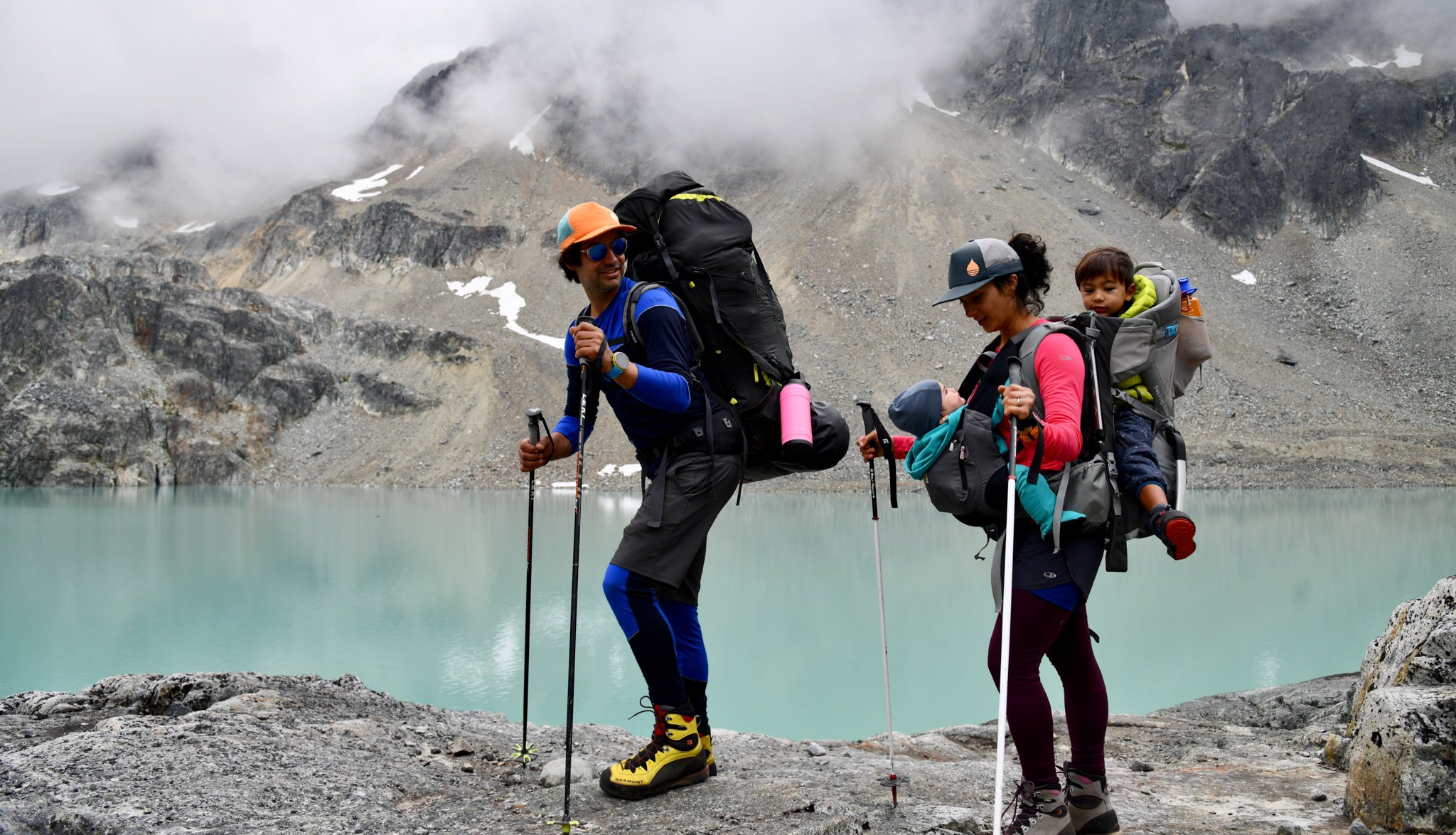 A family of four hiking near a mountain lake. 