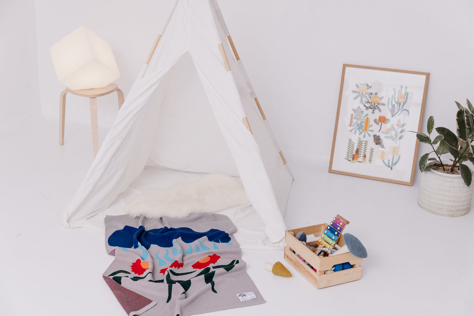 Dancing Daisies blanket under a kids tipi with some toys
