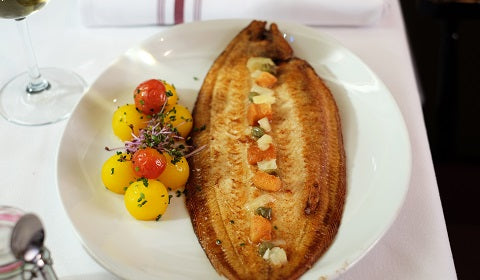 Grilled, whole royal sea bream flambéed in Pastis at Chez Lévêque, THE Parisian Brasserie in Montreal