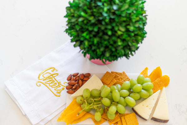 Marble cheese board with bar towel ready to serve guests- memorable hostess tip