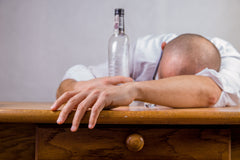 man with empty alcohol bottle
